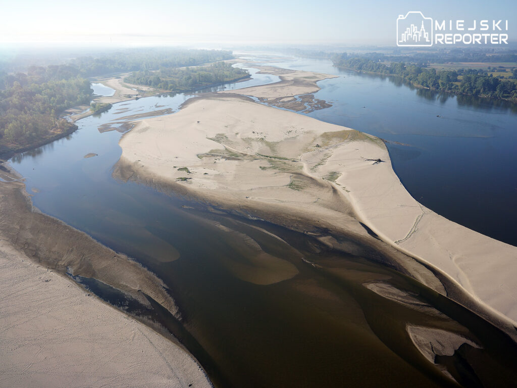 a river flowing through a sandy area