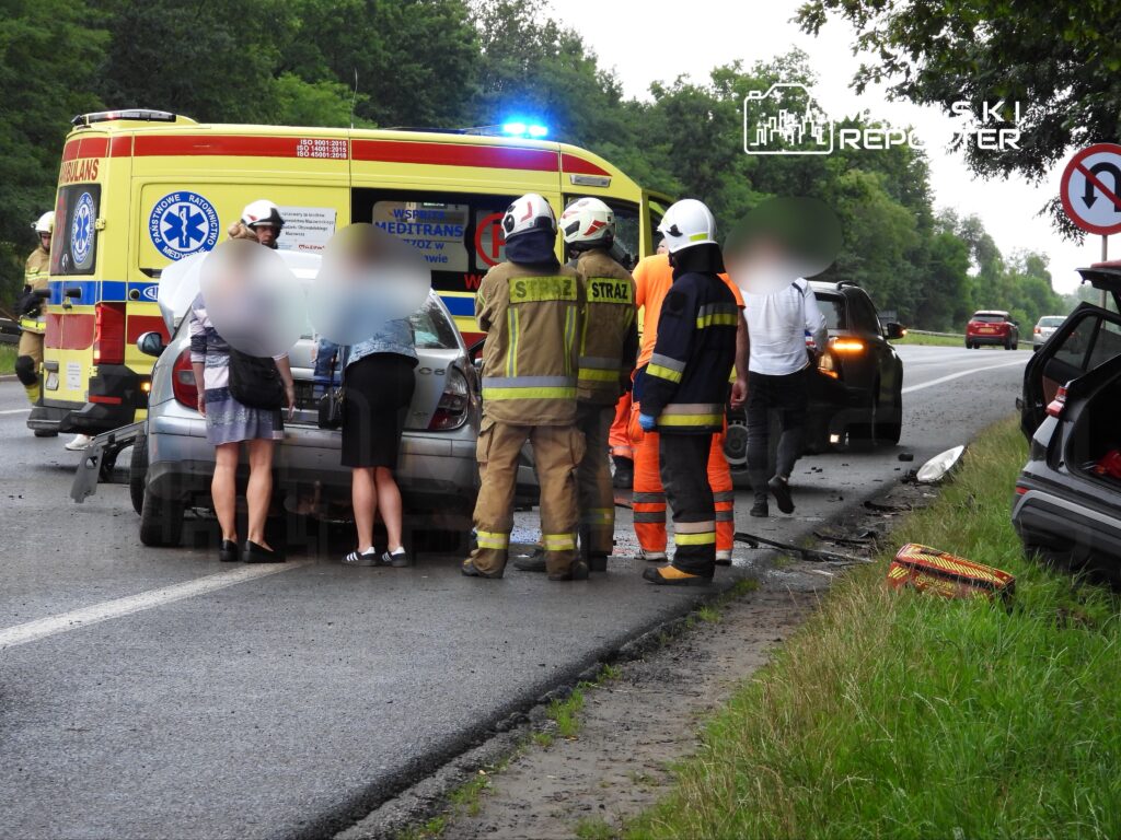Zespół ratunkowy oraz strażacy udzielają pomocy poszkodowanym po wypadku drogowym na ruchliwej drodze.