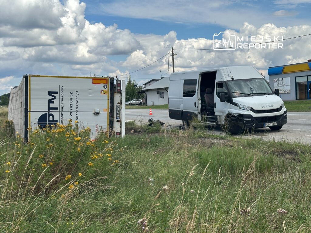 Przewrócona ciężarówka z widocznym napisem "PTM" oraz uszkodzony furgon marki Iveco na poboczu drogi.