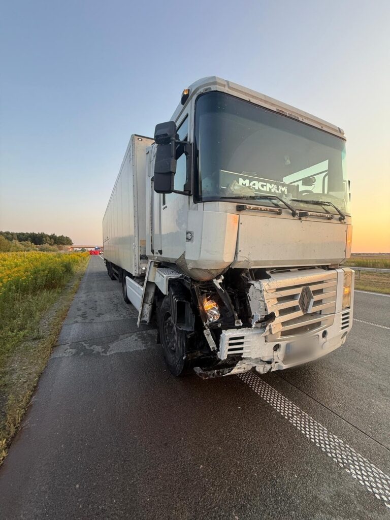 Uszkodzony ciężarówka Renault stojąca na poboczu drogi, z widocznymi śladami kolizji na przednim zderzaku.