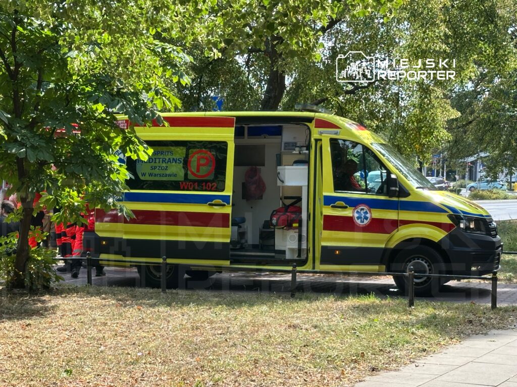 Karetka pogotowia ratunkowego stojąca na ulicy, z otwartymi drzwiami i widocznym wyposażeniem medycznym.
