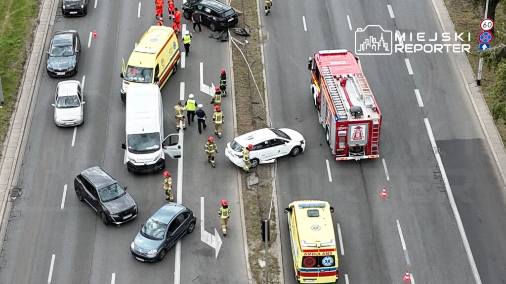 Na drodze znajduje się wypadek, z udziałem kilku pojazdów oraz służb ratunkowych w akcji.