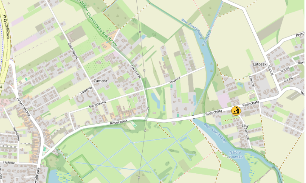 Mapa przedstawiająca obszar z zaznaczonymi ulicami, budynkami oraz rzeka w otoczeniu zieleni.