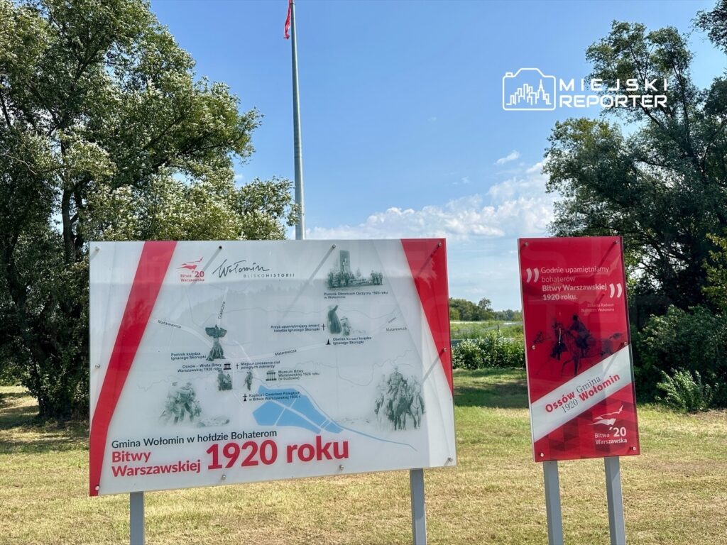 Tablice informacyjne upamiętniające Bitwę Warszawską z 1920 roku, ustawione na tle zieleni.