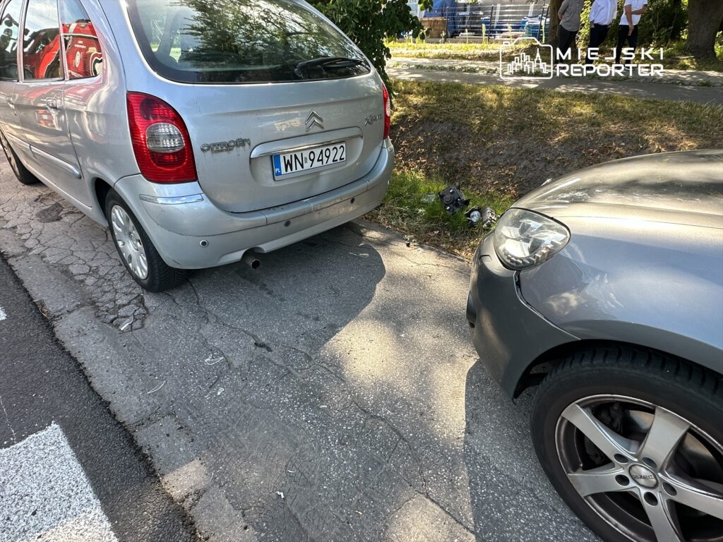 Dwa samochody zaparkowane obok siebie na krętej drodze, jeden z nich to srebrny Citroën z widoczną tablicą rejestracyjną.