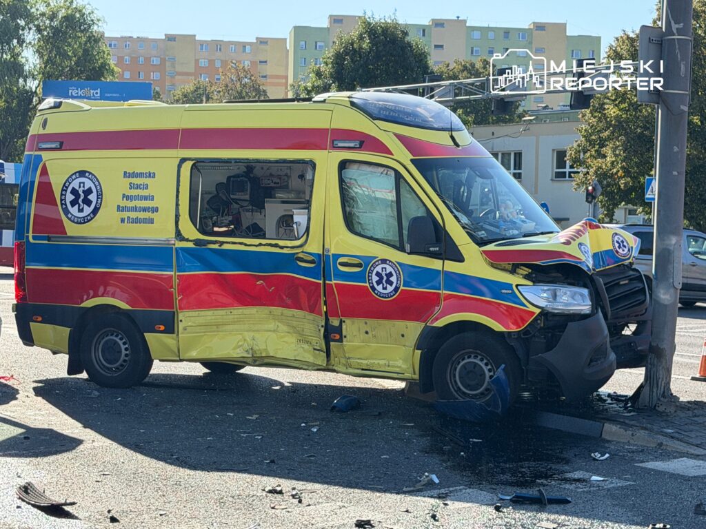 Uszkodzony ambulans z Radomskiej Stacji Pogotowia Ratunkowego stoi na skrzyżowaniu, obok leżące fragmenty pojazdu.