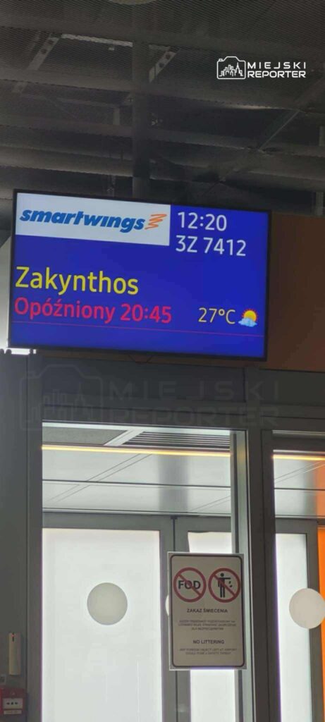 Tablica informacyjna na lotnisku z rozkładem lotów, wskazująca opóźnienie lotu do Zakynthos.