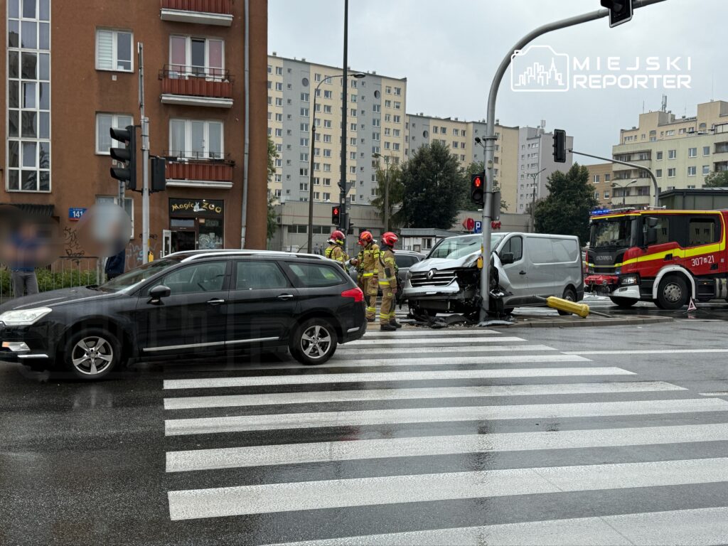 Wydarzenie drogowe z udziałem samochodu dostawczego i osobowego, strażacy udzielają pomocy na skrzyżowaniu.