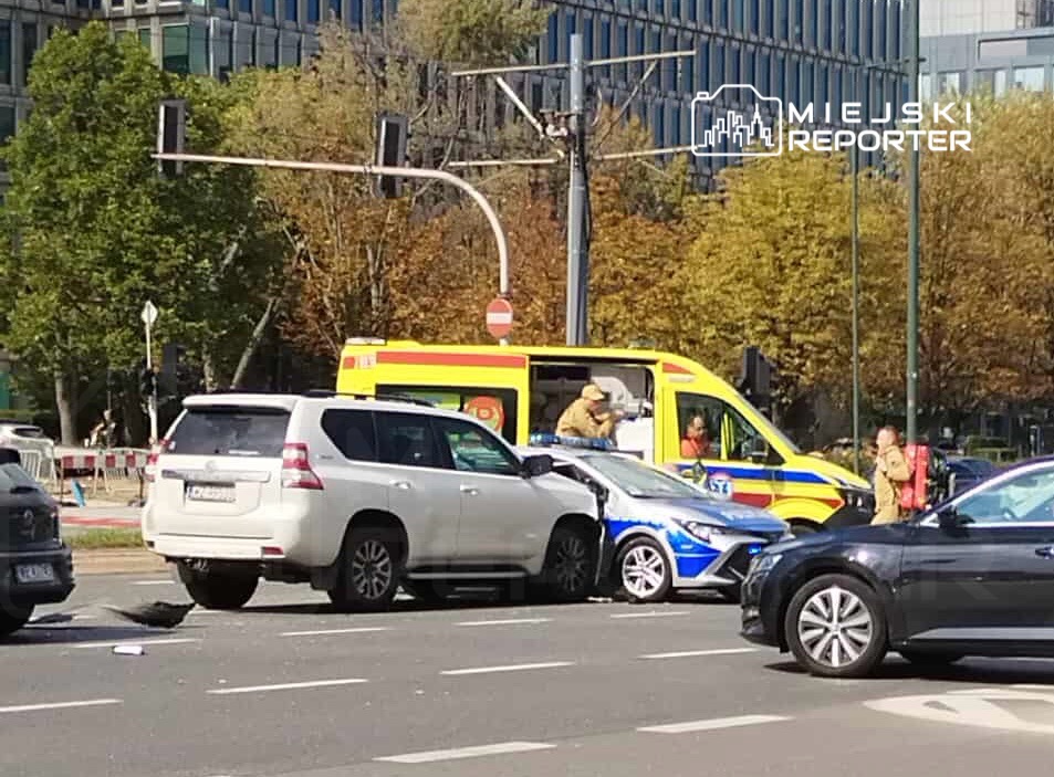 Wielki wypadek drogowy z udziałem dwóch samochodów osobowych oraz karetki pogotowia na ruchliwej ulicy.