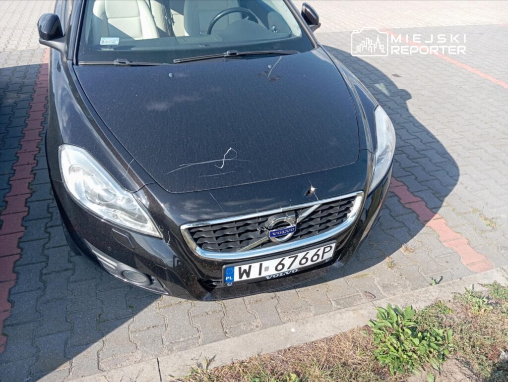 Czarny samochód osobowy marki Volvo zaparkowany na kostce brukowej, z widocznymi smugami na karoserii.