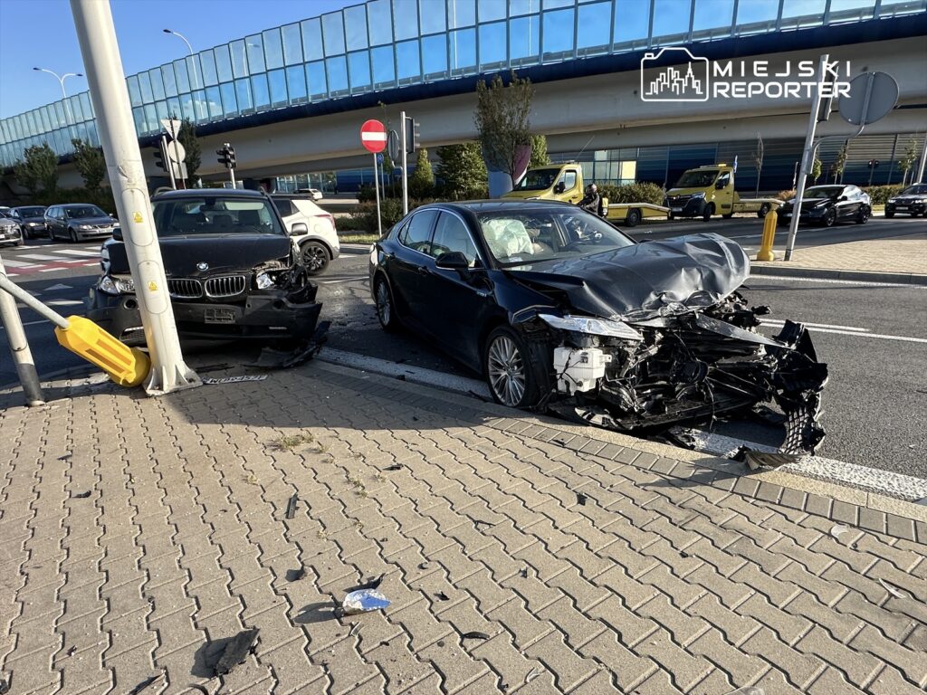 Dwa uszkodzone samochody osobowe na skrzyżowaniu, jeden z nich uderzył w słup sygnalizacji świetlnej.