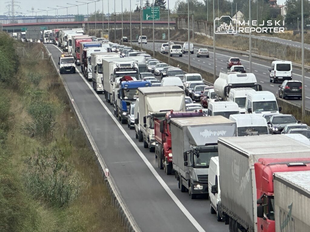 Korki na drodze ekspresowej z wieloma ciężarówkami i samochodami osobowymi w ruchu.