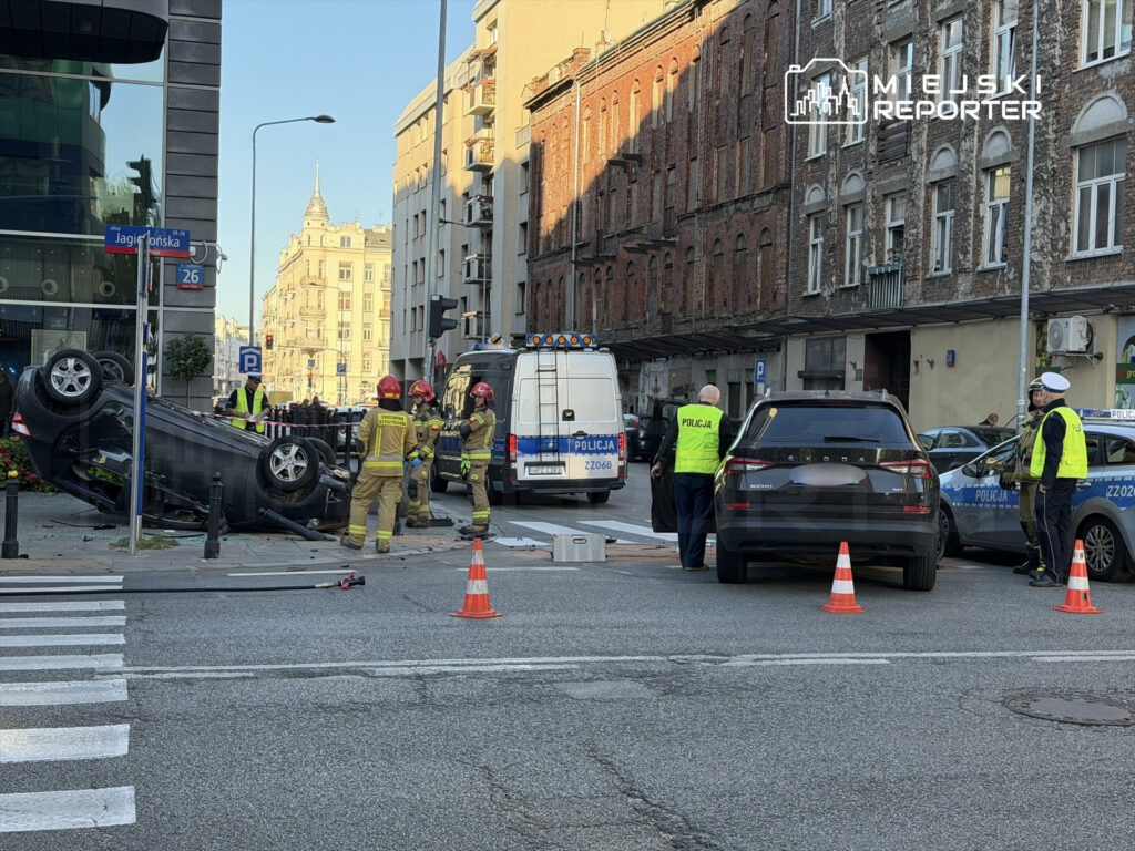 Na skrzyżowaniu ulicy Jagielońskiej leży przewrócony samochód, a obok pracują strażacy i policjanci.