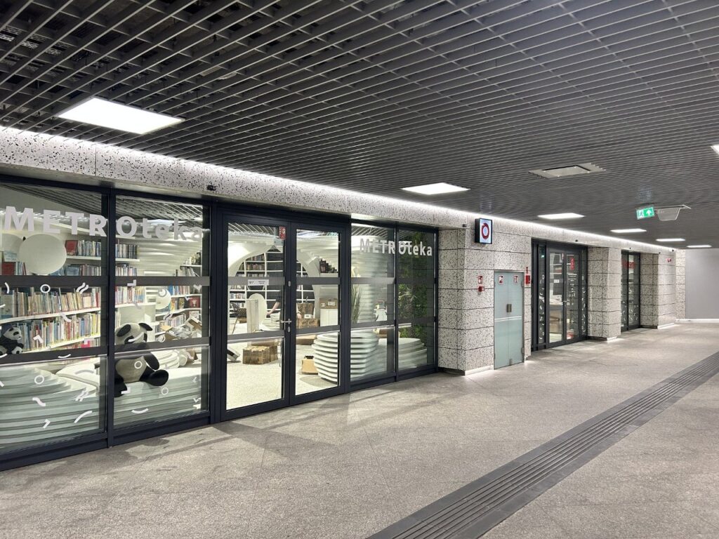 Nowoczesna biblioteka z dużymi przeszklonymi witrynami, z widocznymi regałami książek i dekoracjami w kształcie pand.