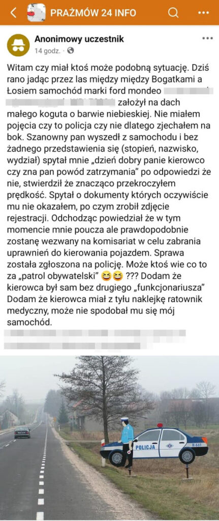 Mężczyzna w niebieskim mundurze policyjnym stoi obok policyjnego samochodu z napisem "POLICJA" na drodze.