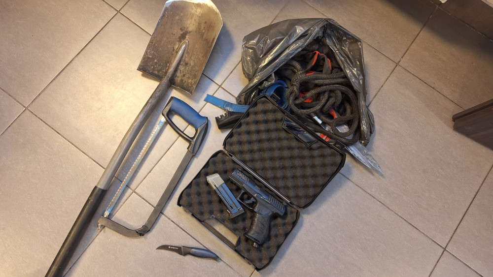 W zestawie narzędzi znajdują się łopata, piła, nóż, pistolet w futerale oraz plecak z linami.