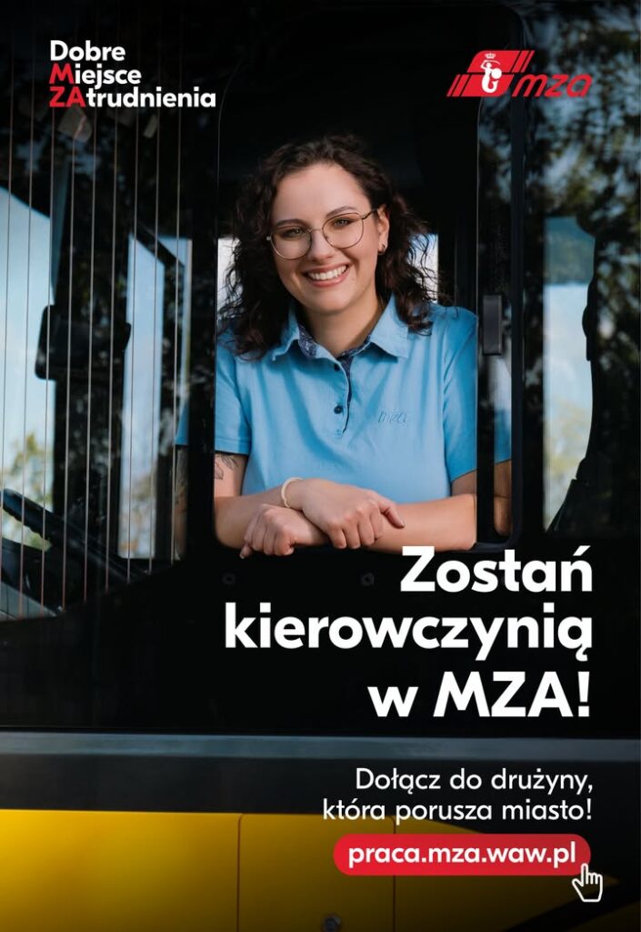 Kobieta w niebieskiej koszuli uśmiecha się, opierając się na kierownicy autobusu, w tle widać zieleń.