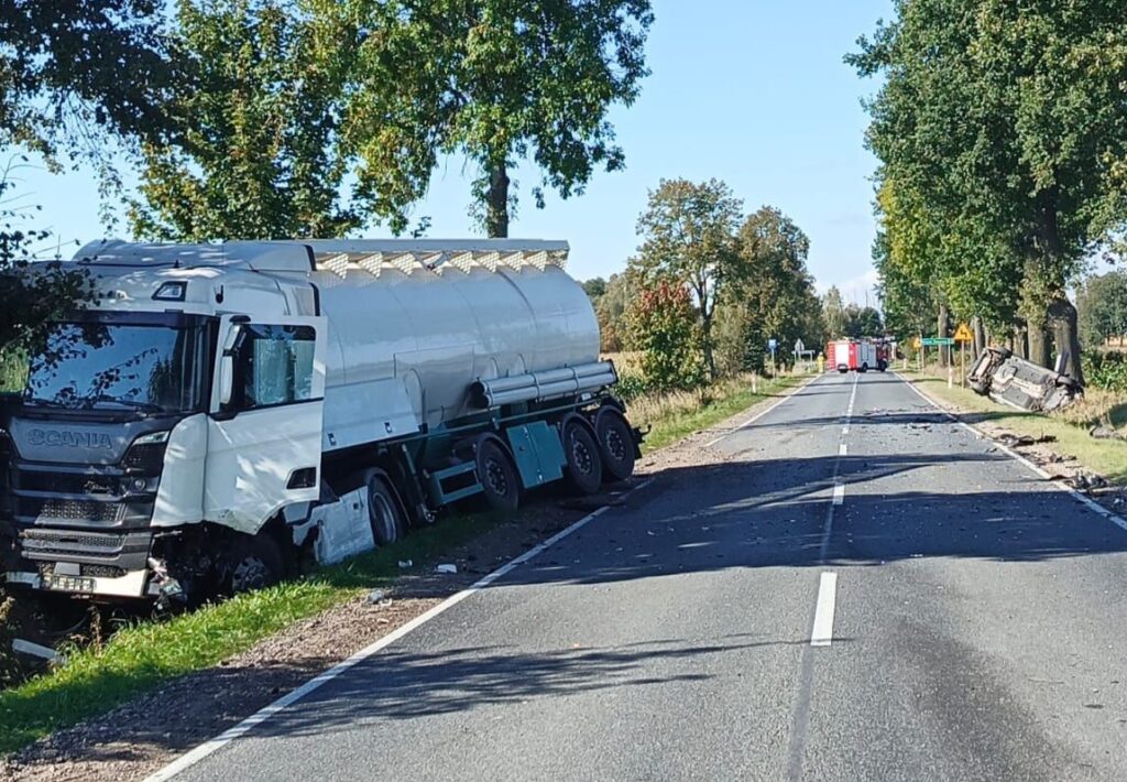Cysternowy samochód ciężarowy w rowie na poboczu drogi, obok leżące wraki innych pojazdów.