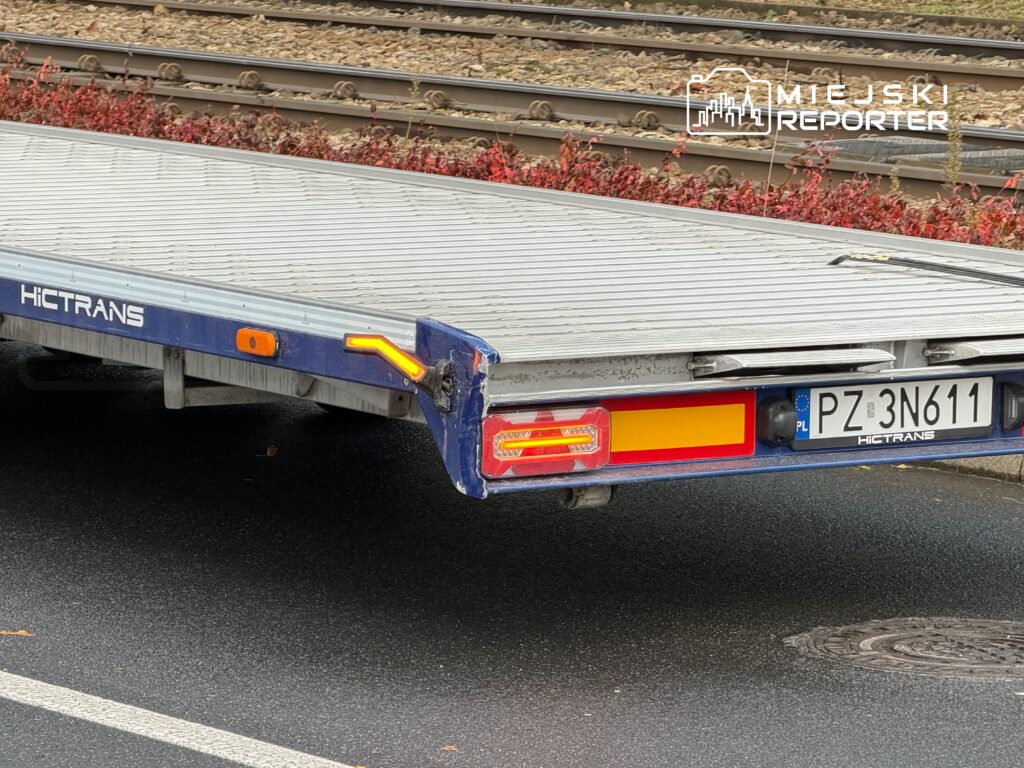 Przyczepa transportowa marki HICTRANS zaparkowana na ulicy, widoczna tylna część z tablicą rejestracyjną PZ 3N611.
