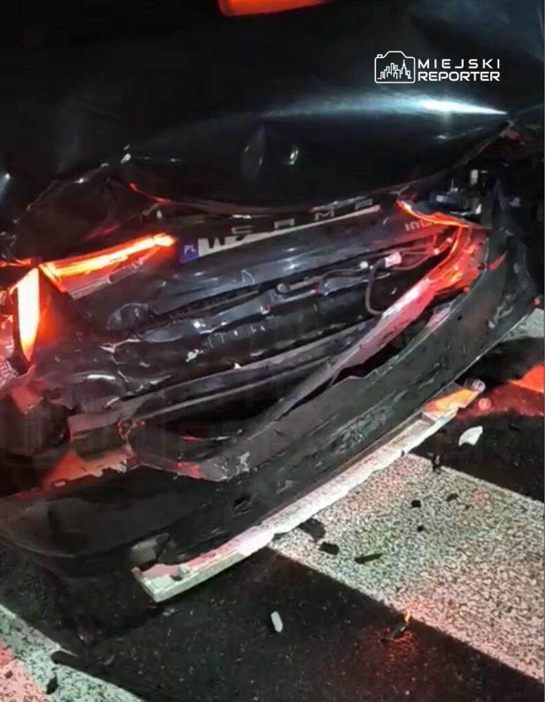 Uszkodzone tylne nadwozie czarnego samochodu osobowego z widocznymi śladami wgniecenia i uszkodzeń.