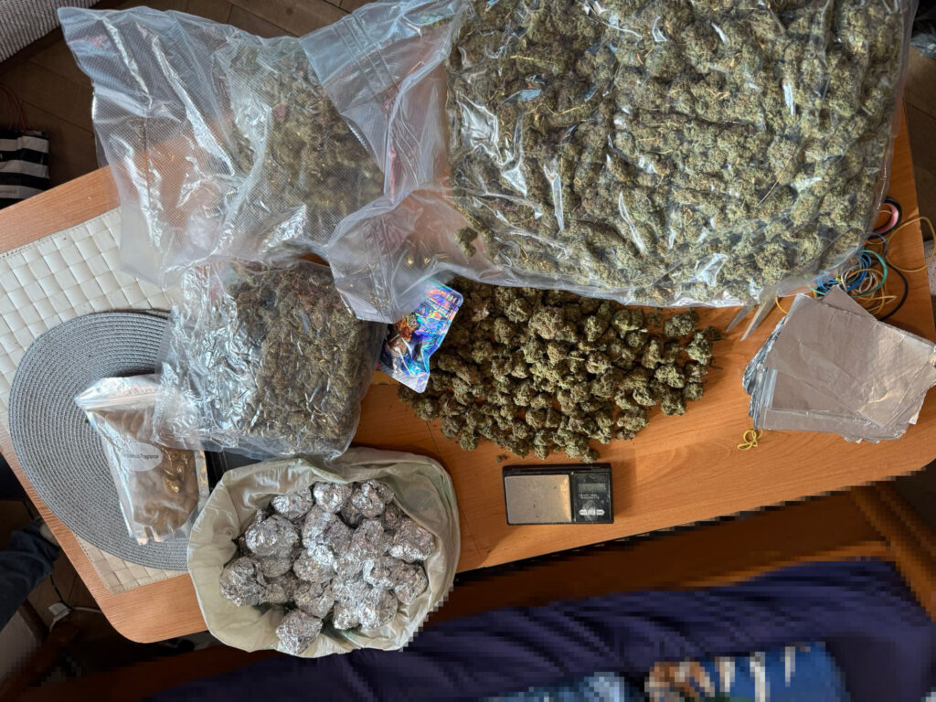 Na stole znajdują się różne woreczki i torebki z suszem roślinnym, w tym duże opakowania oraz mniejsze porcje owinięte w folię aluminiową.