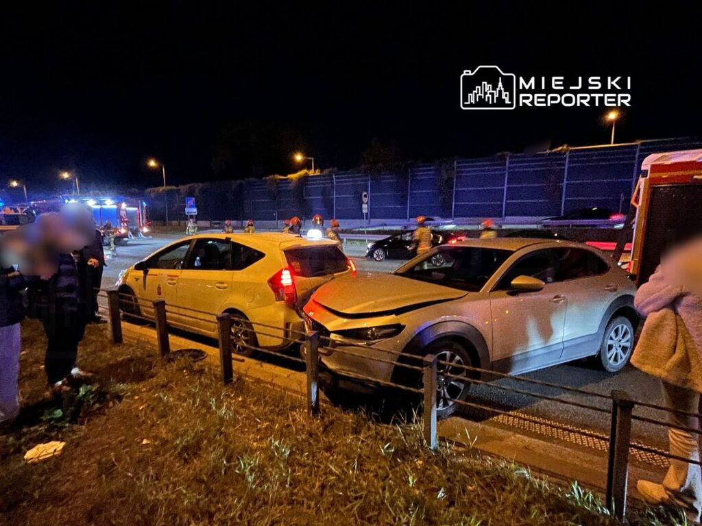 W nocy na drodze doszło do kolizji dwóch samochodów, wokół których zgromadziły się osoby oraz służby ratunkowe.
