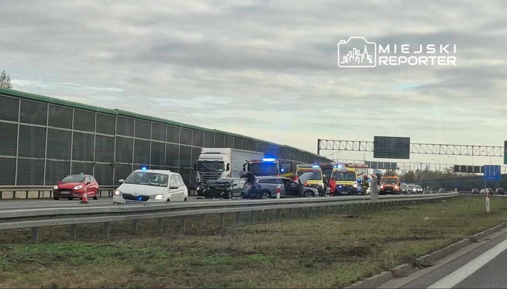 Kolizja drogowa z udziałem kilku pojazdów oraz radiowozów i karetek na autostradzie.
