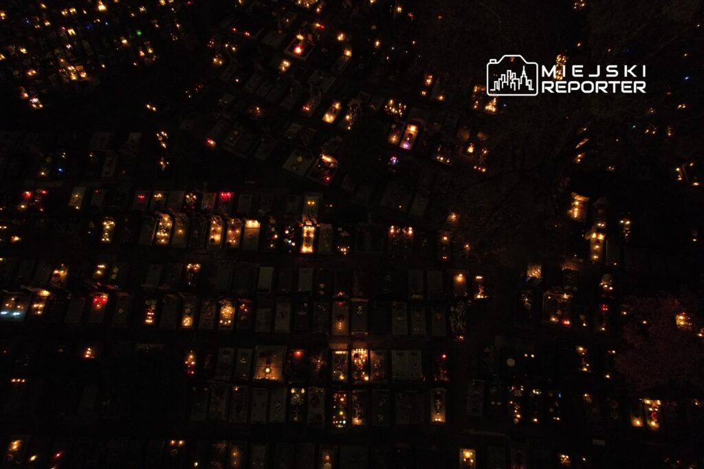 Cmentarz oświetlony setkami zniczy w noc, tworzących atmosferę zadumy i refleksji.