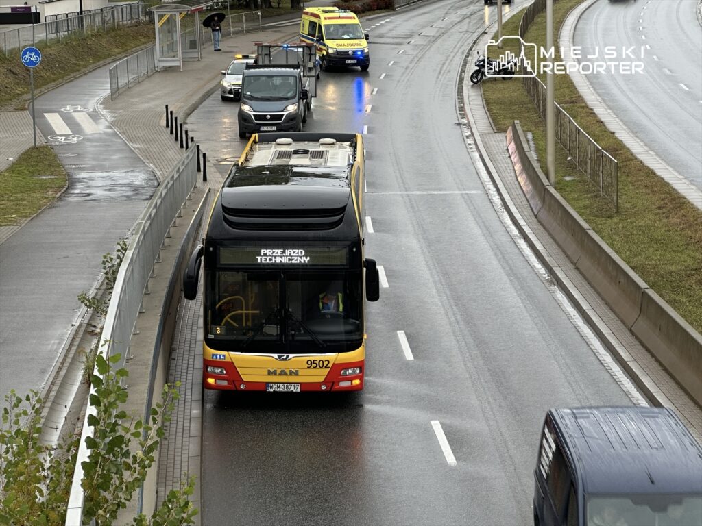 Autobus komunikacji miejskiej z napisem "PRZEJAZD TECHNICZNY" porusza się po drodze, obok pojazdów uprzywilejowanych.