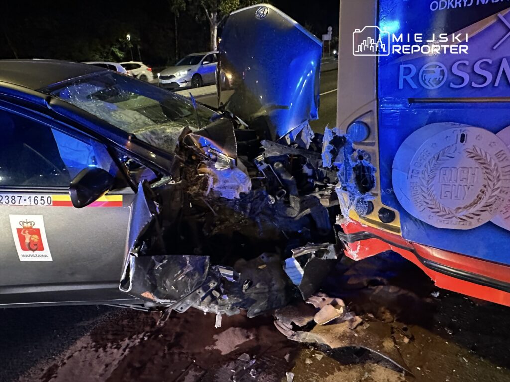 Zderzenie dwóch samochodów na ulicy, jeden z pojazdów z uszkodzoną przednią częścią, w nocy.