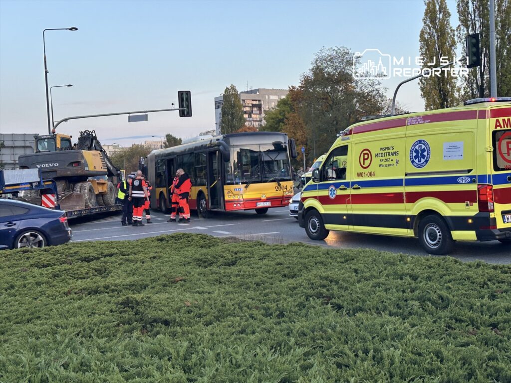 Grupa ratowników medycznych udziela pomocy przy wypadku drogowym z udziałem autobusu i pojazdu ciężarowego.