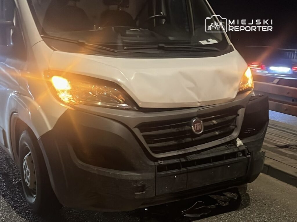 Uszkodzony samochód dostawczy marki Fiat zaparkowany na drodze, z włączonymi światłami awaryjnymi.