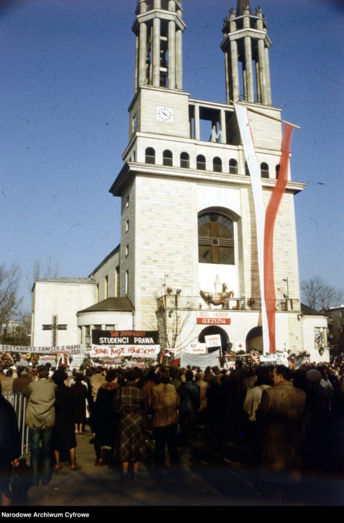 Tłum ludzi zgromadzony przed kościołem z transparentami, w tym "STUDENCI PRAWA" i "BOG HONOR OJCZYZNA".