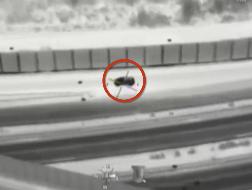 Samochód osobowy zatrzymany na autostradzie, widoczny z perspektywy kamery termowizyjnej.