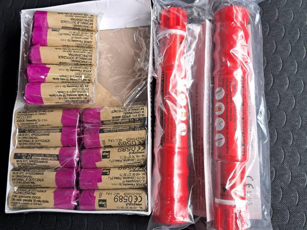 Pakiet fajerwerków zawierający różowe petardy oraz dwa czerwone wyrzutnie, zapakowane w przezroczyste folie.