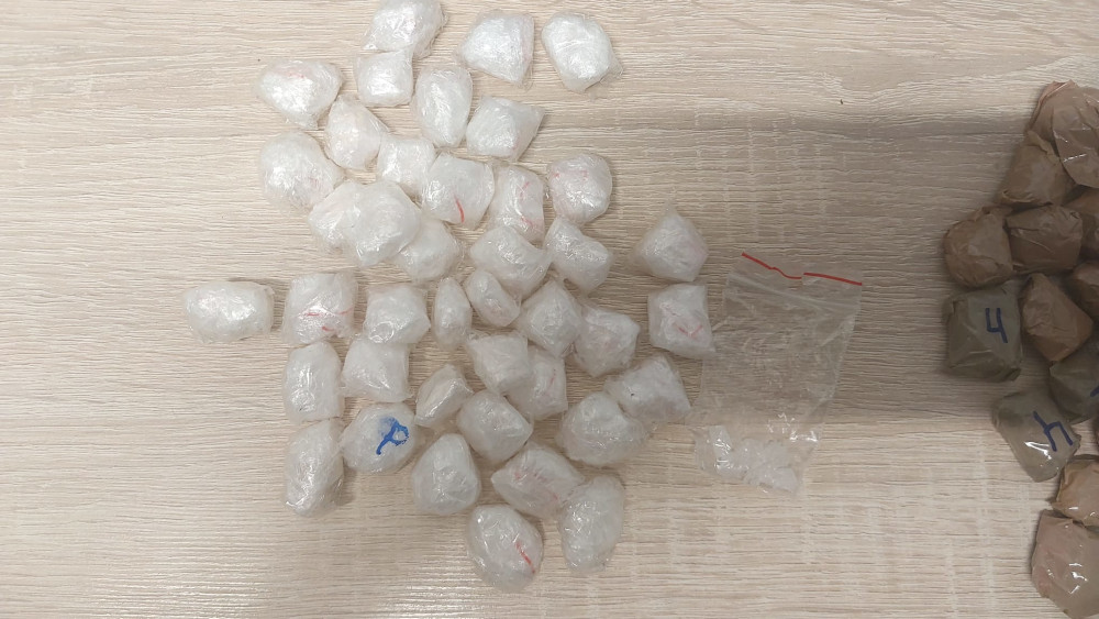 Zestaw przezroczystych torebek z białym proszkiem ułożonych na jasnym blacie, obok pustej torebki strunowej.