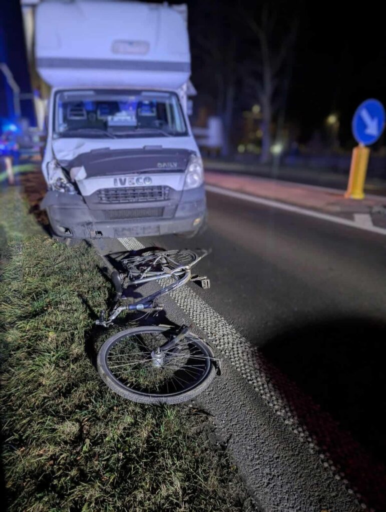 Uszkodzony samochód dostawczy stoi na poboczu drogi, obok leży przewrócony rower.