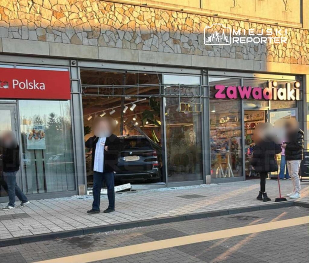 Grupa osób stoi przed sklepem z napisem „Zawadiaki” oraz innym sklepem oznaczonym „Media Polska”, w tle widoczna jest rozbita szyba.