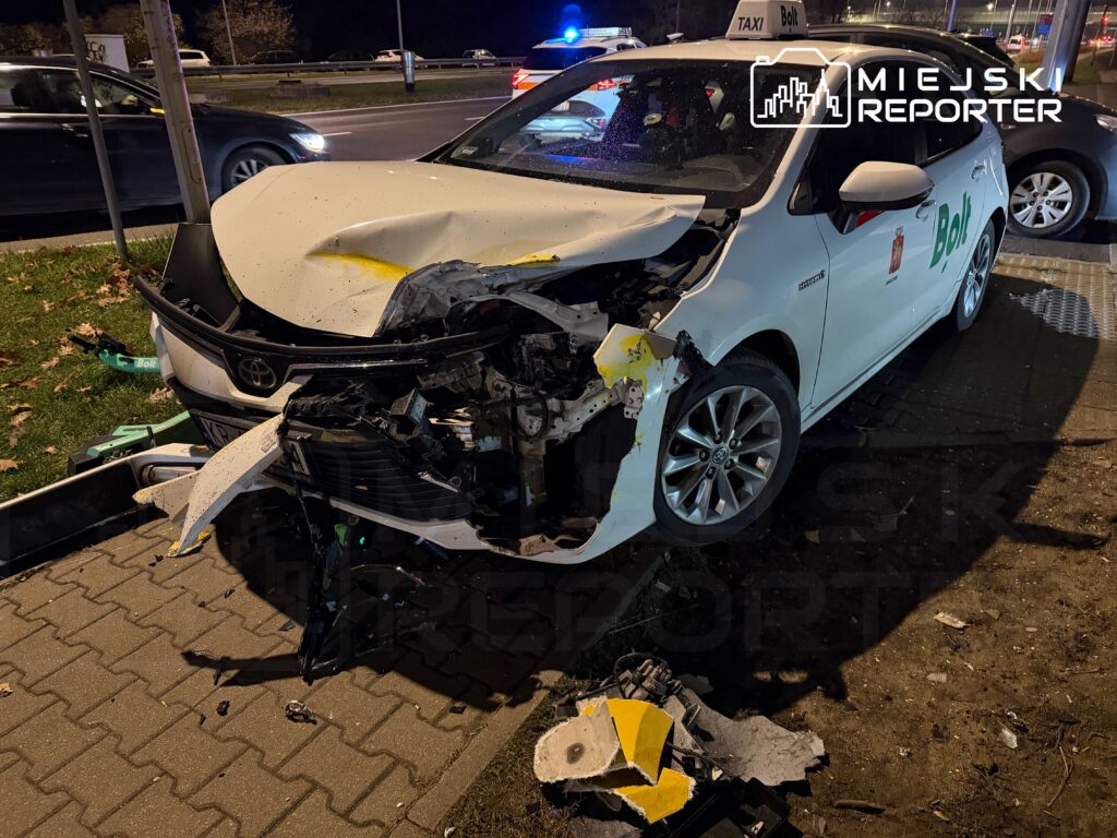 Uszkodzony samochód osobowy marki Toyota z wgniecionym przodem stoi na chodniku obok drogi.