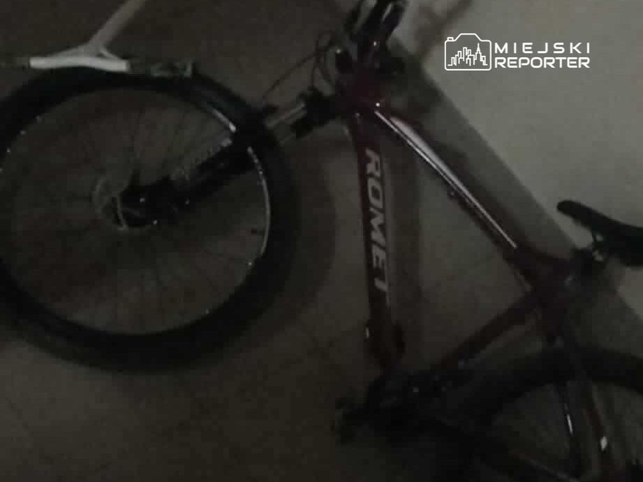 Rower marki Romet leży na podłodze w słabo oświetlonym pomieszczeniu.