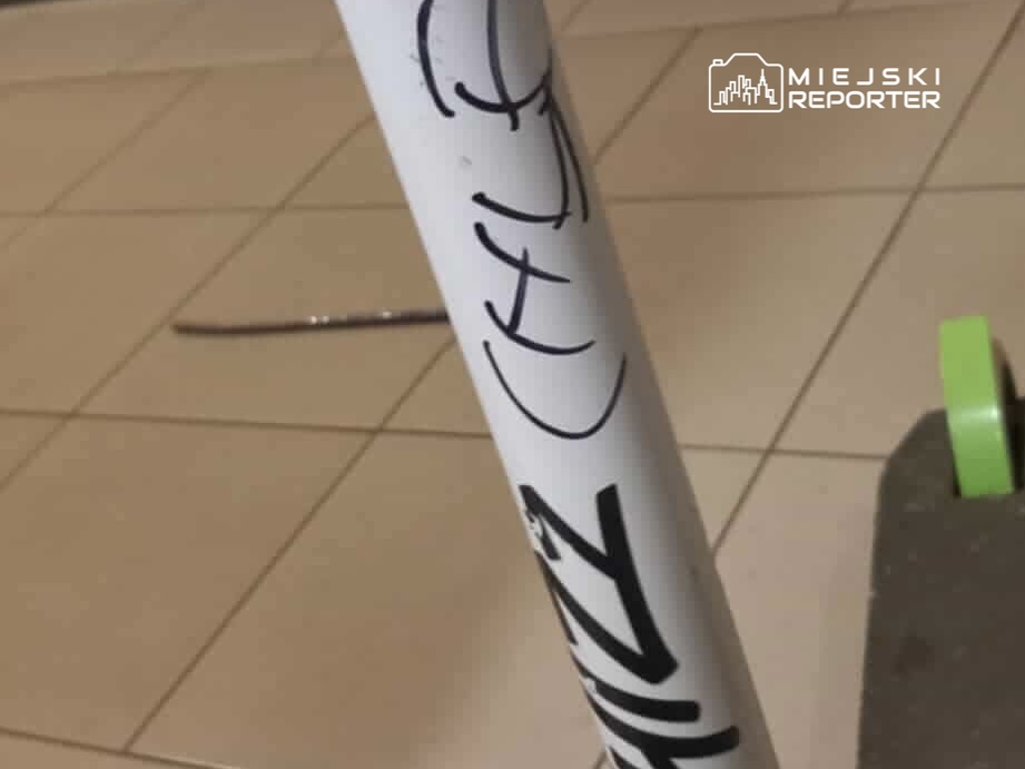 Biała rurka z graffiti, na której widnieje napis "CHILL", stoi na jasnej, płaskiej powierzchni obok zielonego elementu.