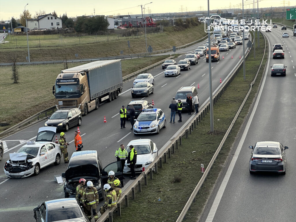 Wielu ratowników medycznych i strażaków pracuje przy zderzeniu dwóch samochodów na ruchliwej drodze.
