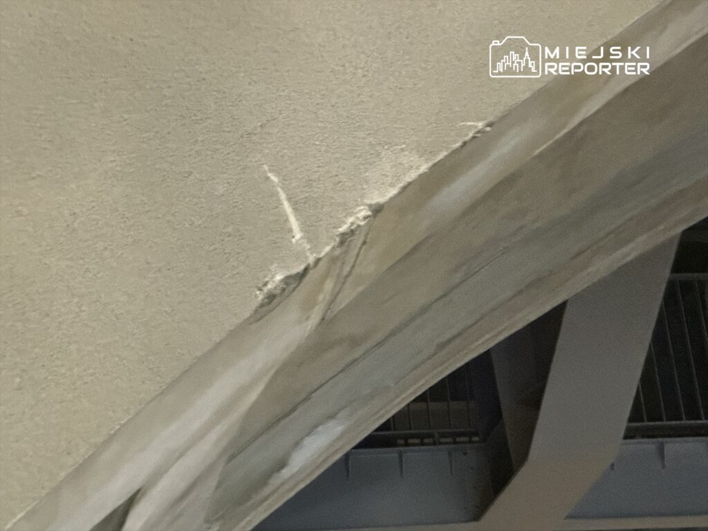 Pęknięcie na ścianie w nowoczesnym wnętrzu, z widocznym fragmentem konstrukcji podtrzymującej.