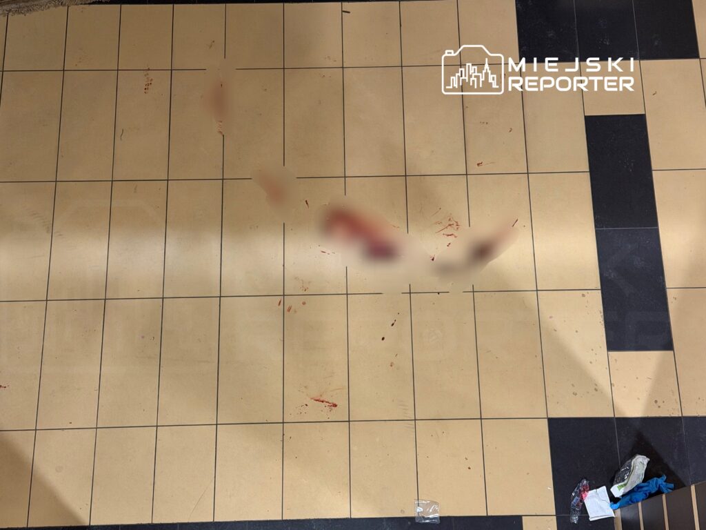 Na podłodze w pomieszczeniu widać plamy krwi oraz porozrzucane śmieci.