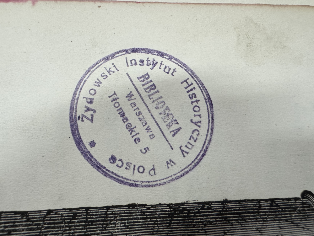 Stempel biblioteczny Żydowskiego Instytutu Historycznego z adresem w Warszawie na białym tle.