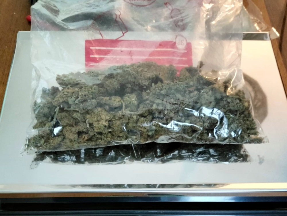 Pakiet z suszem roślinnym znajduje się na wadze elektronicznej na blacie.