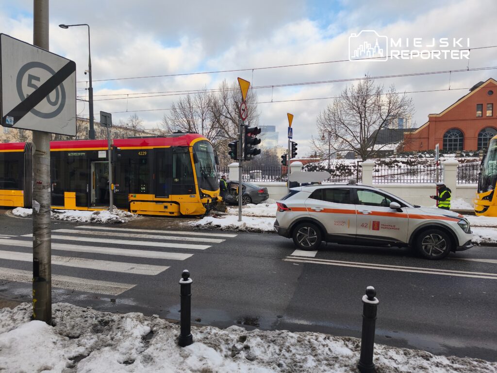 Tramwaj z numerem 4229 zatrzymany na przystanku w zimowej scenerii, obok zaparkowany samochód służbowy.