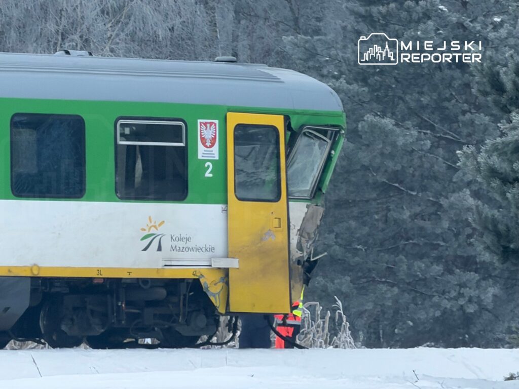 Pociąg Kolei Mazowieckich z uszkodzoną kabiną stoi w zaśnieżonym terenie, w tle drzewa pokryte szronem.