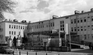 Nowoczesny budynek szpitala z przeszkloną fasadą i oznaczeniem "Szpital Specjalistyczny im. Świętej Rodziny SPZOZ".