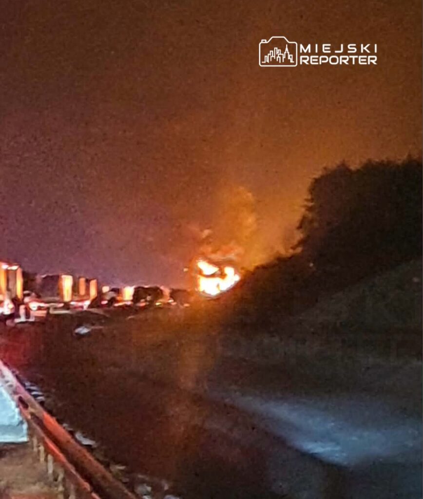 W tle widać pożar na poboczu drogi, a w pierwszym planie stojące tiry w korku.